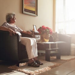 Woman sitting a furnished care home room